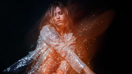 Attractive dancing blonde in the club, shining golden light, motion effects.の写真素材