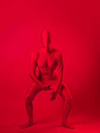 crazy red man on a red background. figure in a leotard covering the whole bodyの写真素材