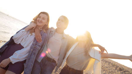 Three friends are walking on the beach, the happiness of communication.の写真素材