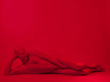 crazy red man on a red background. figure in a leotard covering the whole bodyの写真素材