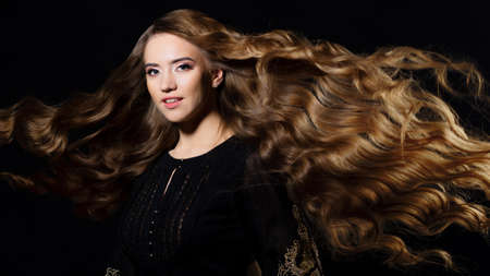 Attractive blonde with very long hair, wavy hair flying in the wind,