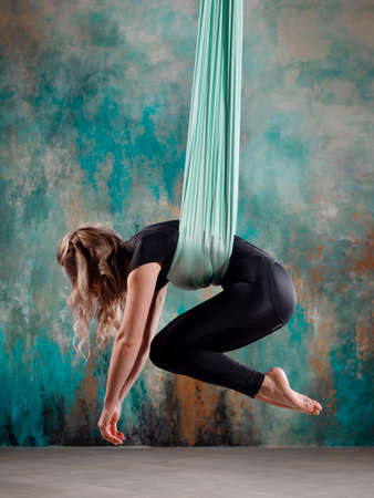 Aero yoga, a young woman doing yoga or stretching on a suspension,の写真素材