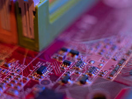 Computer motherboard, microchips close-up in color illumination,