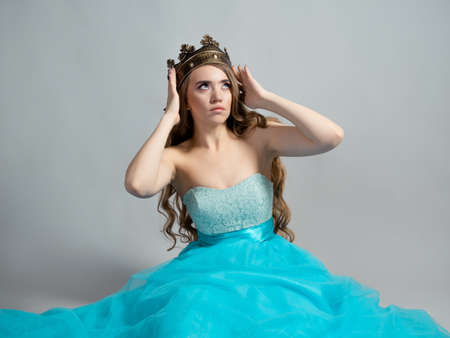 charming princess in a crown. Young beautiful blonde with long wavy hairの写真素材