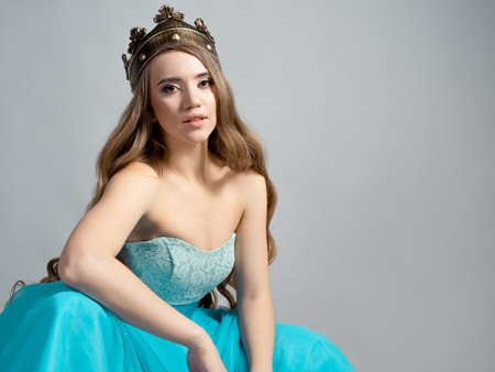 charming princess in a crown. Young beautiful blonde with long wavy hairの写真素材