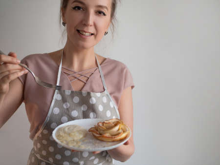 happy female chef cook holds a plate of apple roses
