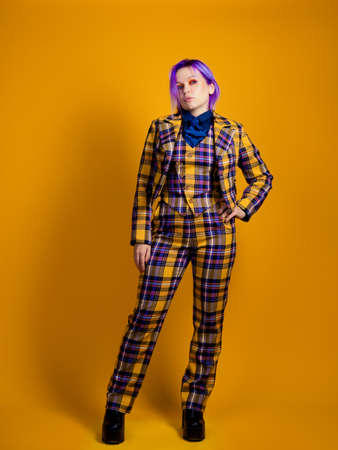 young woman with purple hair in a stylish bright plaid suit.の写真素材