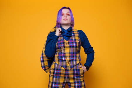 young woman with purple hair in a stylish bright plaid suit.の写真素材