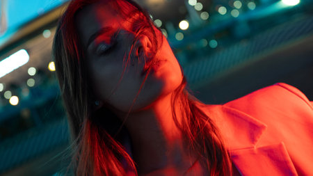 A young stylish brunette in the lights of the night city, neon lighting,