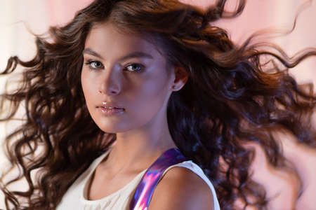 Beautiful young brunette with long curls, lush beautiful curls,