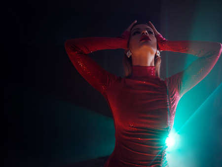 Glamorous portrait of a young beautiful blonde in a stylish scarlet dress, stylish shooting with...
