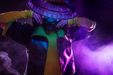 Futuristic character in a bright stylized outfit, wearing an asian mask. photo with neon colors. A fantastic character, a cyber mercenaryの写真素材