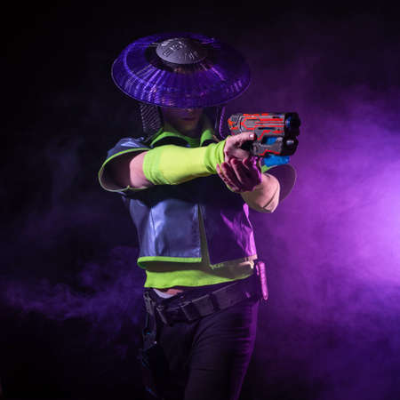 Futuristic character in a bright stylized outfit, fires a blaster. photo with neon colors. A...