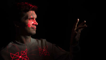 Interaction with augmented reality virtual interface, concept. A young man with projections of red...