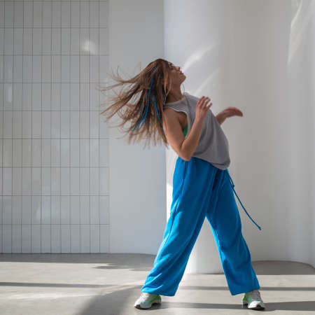 Youth jazz-funk dance style. Young and free, dancing in baggy clothes in a bright white hall....