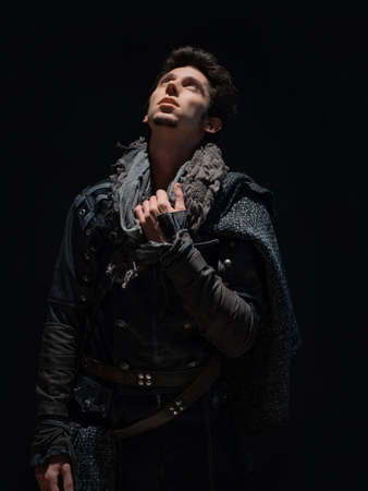 A guy in a steampunk or post-apocalyptic image, looking up, the overhead light on his face. a moment of calm.の写真素材