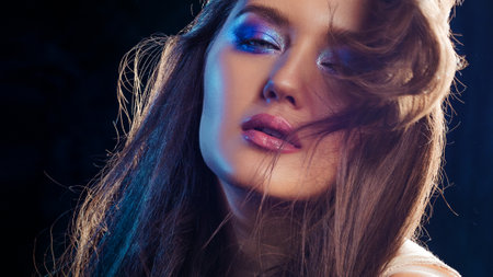 Gorgeous brunette with long beautiful hair. Bright makeup, shining eye shadow. Beautiful styling and makeup, glamorous divaの写真素材