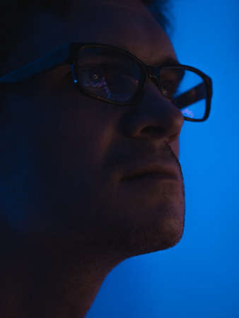 pulse of the market, a male trader with glasses sits in front of the monitor and looks at the chart...