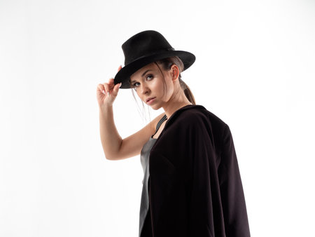 Stylish young woman in a black hat and jacket, close-upの写真素材