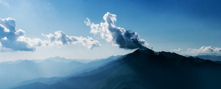 cloud caught on the top of the mountain. Beautiful mountain landscape, clouds over the peaks of the...