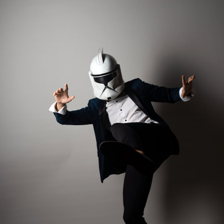 SAINT PETERSBURG, RUSSIA - SEPTEMBER 29, 2020: Respectable man in a tuxedo with a bow tie and a helmet of a combat star stormtrooper, business geek, illustrative editorialのeditorial素材