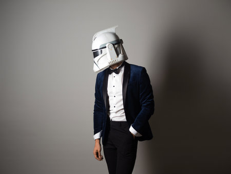 SAINT PETERSBURG, RUSSIA - SEPTEMBER 29, 2020: Respectable man in a tuxedo with a bow tie and a helmet of a combat star stormtrooper, business geek, illustrative editorialのeditorial素材