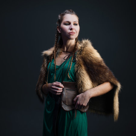 A Viking warrior woman in a fur cape. portrait on a black backgroundの写真素材