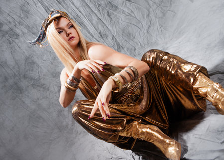 Golden mystical heroine in a luxurious oriental-style costume with a headdress with hornsの写真素材