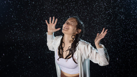 young woman in the rain, getting wet through, wet clothes and water running down her face. screaming...