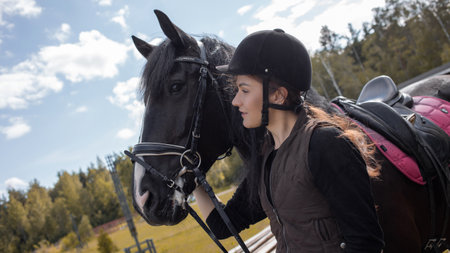 Equestrian sports. A young woman, a rider and her horse, going out for training near the stable