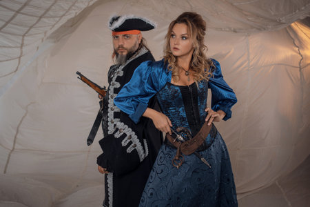 A lady and a pirate in an antique doublet and hat, a couple in pirate costumes. sails on the backgroundの写真素材