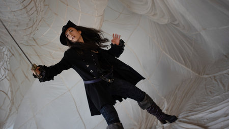 Lady pirate attacks with a saber, boarding. beautiful young brunette in a pirate costume