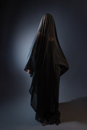 graceful young woman wearing a long, black veil.の写真素材
