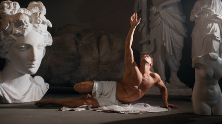 To appeal to the gods. A muscular man in a tunic stretches his hand to the sky, antique aesthetics, a bodybuilder among sculpturesの写真素材