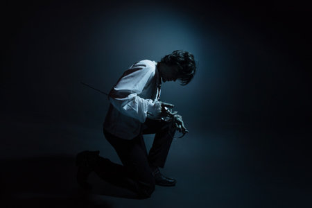 A dramatic hero with a sword in his hands, suffering from defeat and injury, a portrait in the moonlight, drama or theaterの写真素材