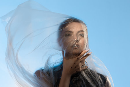 Compress and limit yourself from the outside world, portrait under cellophane, conceptの写真素材