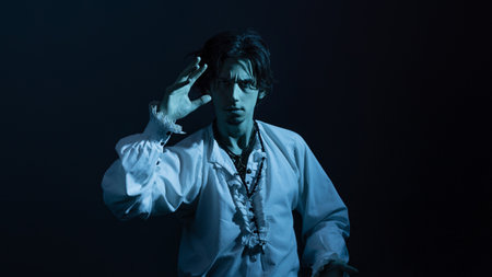 A dramatic hero in a white vintage blouse makes spectacular poses, a portrait in the moonlightの写真素材