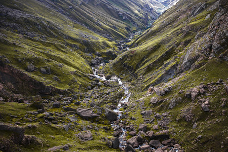 An epic view of a huge mountain rift, the terrain is covered with greenery, the canyon is visible...