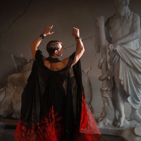 Muscular charismatic bodybuilder model in a silk cape makes an expressive pose, sculptors workshopの写真素材
