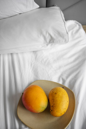 ripe juicy yellow mango on a plate, breakfast in bedの写真素材