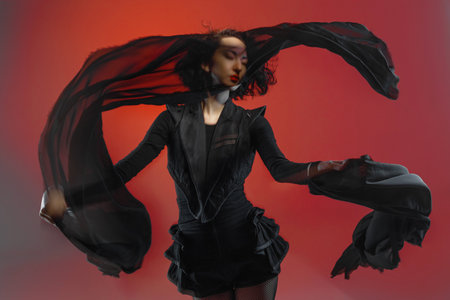 fashion woman dancing with fabric canvases, photo in motion with artistic motion blur, scarlet tonesの写真素材