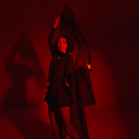 stylish Asian fashion woman in stylish shorts dancing with fabric canvases, photo in motion with artistic motion blur, red spotlight, totally red lightの写真素材