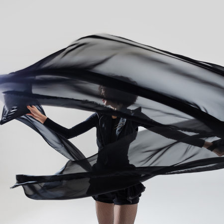 stylish fashion woman in stylish shorts dancing with fabric canvases, black silhouette on a white background, graphic styleの写真素材