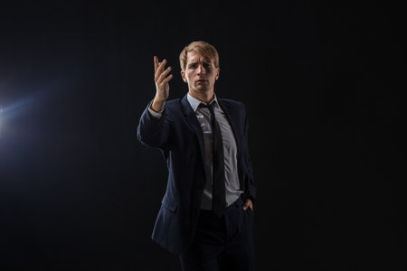 The business leader gives a motivational speech. A man in a speakers suit, photo on a dark backgroundの写真素材