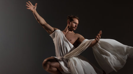 A muscular, athletic figure embodying Zeus, Epic pose, tunic flapping in the wind. the ancient Greek god of thunder, stands powerfully with a toga draped over his shoulders.の写真素材
