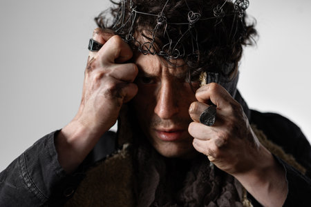 Hamlet in modern grunge or post-apocalyptic reinterpretation, young man, tragic Shakespearean hero in a crown of wire, Contrast lighting, super close-upの写真素材