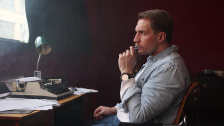 Smoke-filled vintage office with writer at work, cinematic soft lighting highlighting typewriter and papers.の写真素材