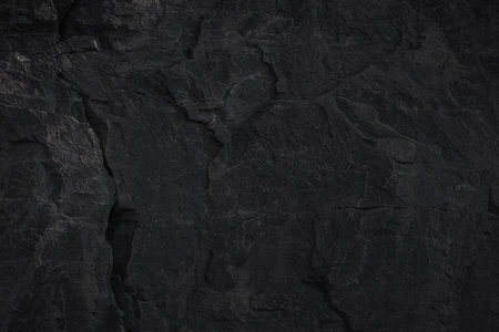 A textured stone background showcasing a brutal, monolithic rock formation with cracks and fragments. Perfect for design templates, banners, or projects highlighting natural power and beauty.の写真素材
