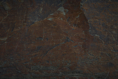 A textured stone background showcasing a brutal, monolithic rock formation with cracks and fragments. Perfect for design templates, banners, or projects highlighting natural power and beauty.の写真素材