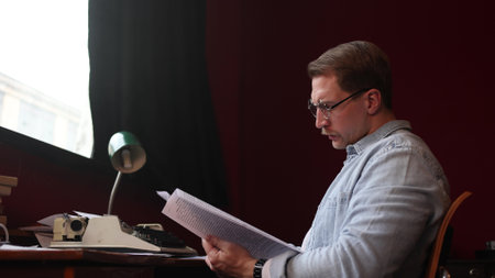 Pensive author in vintage office, cinematic soft lighting on typewriter and smoke-filled creative space.の写真素材